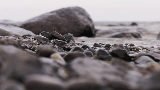 Waves crash on stone. Windy autumn weather on the shore of Lake Ilmen. Selective focus.