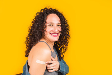Portrait of a woman smiling after receiving a vaccination.