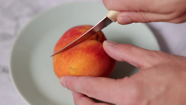 Process slicing and cutting a peach in the hand