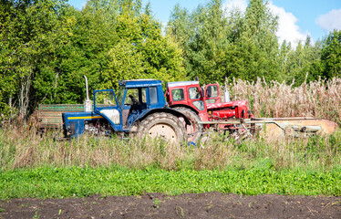 Fototapeta premium Wheeled agricultural tractors working at the potato plantation