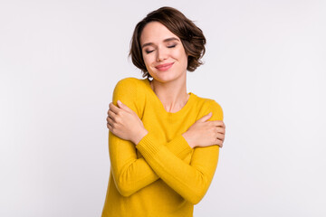 Photo of young attractive woman happy positive smile hug herself comfort cozy isolated over grey...