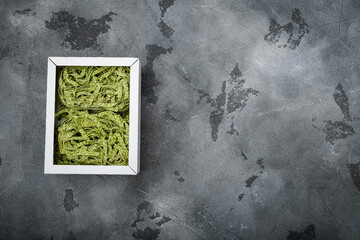 Raw green pasta pack, on gray stone table background, top view flat lay, with copy space for text