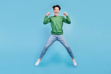 Full length body size photo guy smiling jumping up careless gesturing like winner isolated pastel blue color background