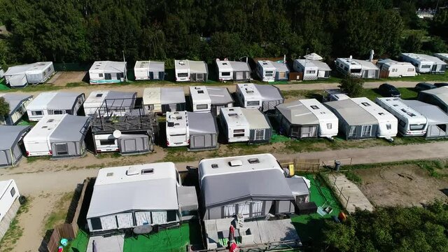 Campsite by the sea in summer vacations, aerial view. Picturesque situated camping at Baltic sea coastline with cottages, RV, caravan and motorhome. Campsite with beautiful seaside landscape.