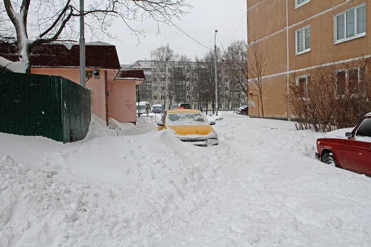 Taxi got stuck in a snowdrift after night snowstorm in yard in Vidnoe