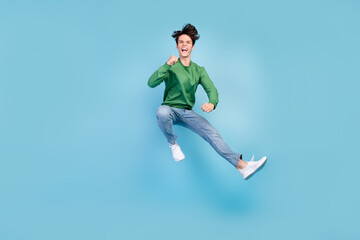 Fototapeta na wymiar Full length body size photo guy jumping high gesturing like winner isolated pastel blue color background