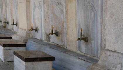 Ablution or wudhu station at mosque in Istanbul, Turkey. Faucets for ritual ablution and stones to...