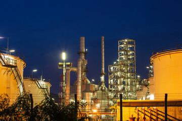 Fototapeta premium Twilight scene of tank oil refinery plant and tower column of Petrochemistry industry