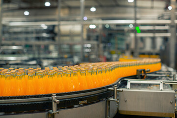 Beverage factory interior. Conveyor flowing with bottles for juice