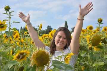 Happy, carefree young woman, outdoors in a sunflower field