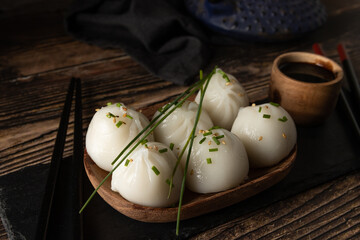 Steamed pork and prawn dim sum on slate stone on wooden table