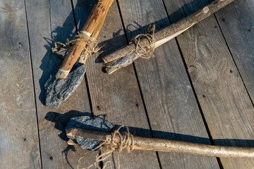 ancient stone axe and stone spear on a wooden background