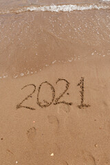 inscription on the sand 2021. symbol 2021 on the coast, overlooking the sea. Summer holidays in the new season.
