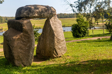 large stones are made on the shore of the lake on a sunny day.
