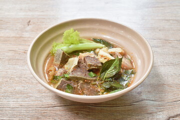 hot and spicy beef meat and organ with tamarind and Thai herbs soup on bowl