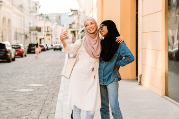 Two smiling young muslim women walking