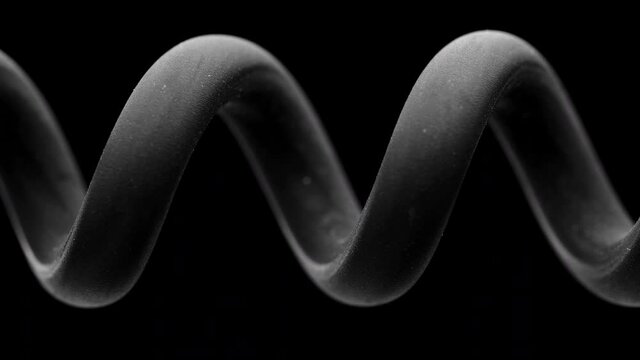 Spring is compressed and expanded against a black background.