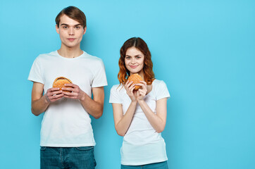 young couple with hamburgers in their hands fast food snack junk food