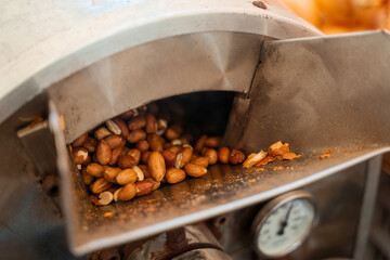 Roasting and blanching peanuts. Process of peeling peanuts in machine.