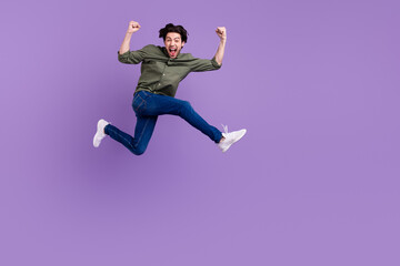 Fototapeta na wymiar Full body photo of crazy cheerful happy young man jump up cool runn winner isolated on violet color background