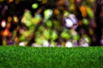 Naklejka premium Green artificial grass on natural daylight bokeh blur background