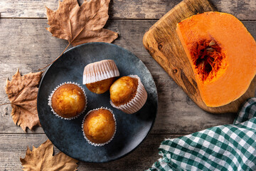 Pumpkin muffins on rustic wooden table. Autumn dessert