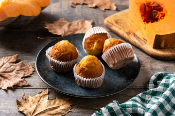 Pumpkin muffins on rustic wooden table. Autumn dessert