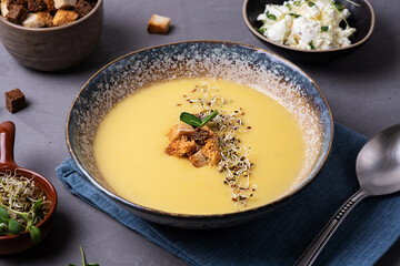 Healthy food concept, homemade vegetarian squash cream soup with croutons and microgreens.