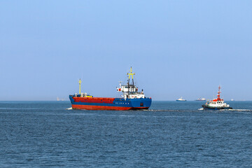General Cargo Ship and tugboat in open sea, close up