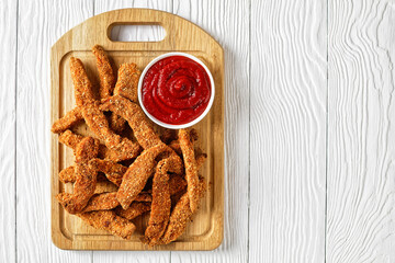 crunchy Baked Chicken Tenders on a wooden board