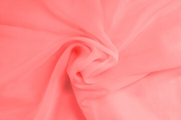 Background from folds of pink fabric rolled up in middle close-up.