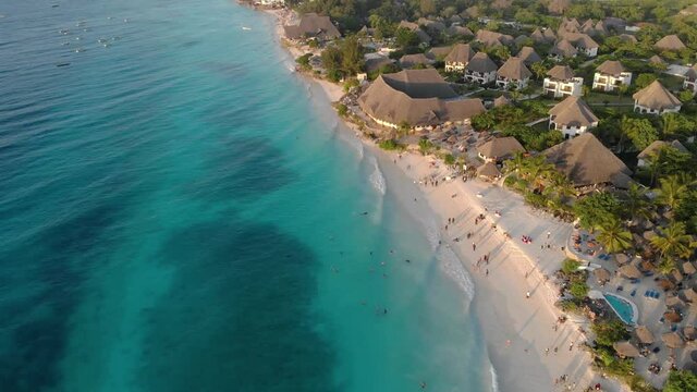 aerial view of thatched roof of luxury ocean view resort at the beautiful white sand ocean coast in nungwi beach evening time sunset at zanzibar island tanzania