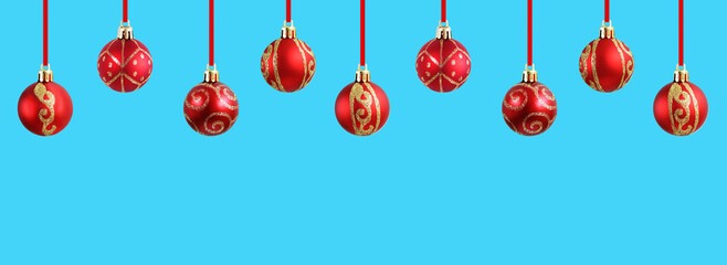 Red Christmas balls on ribbon. Turquoise background. Banner for the site.