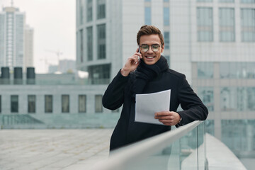 Businessman talk on cellphone and look on document