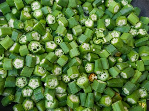 Fresh raw lady finger vegetable cut into small pieces. Okra or okro, abelmoschus esculentus. Green vegetable background. This vegetable is also called as bhindi in local language. 