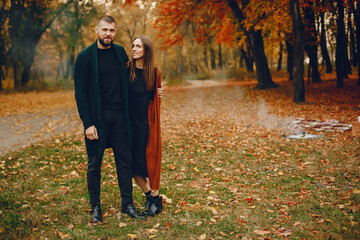 Fototapeta premium Elegant couple spend time in a autumn park