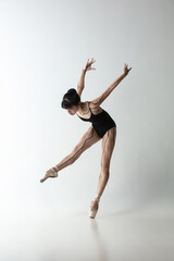 Japanese female ballet dancer, ballerina dancing isolated on light gray studio background. Art, motion, action, flexibility, inspiration concept.