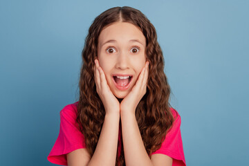 Portrait of charming excited girl hands cheekbones look camera open mouth scream on blue background