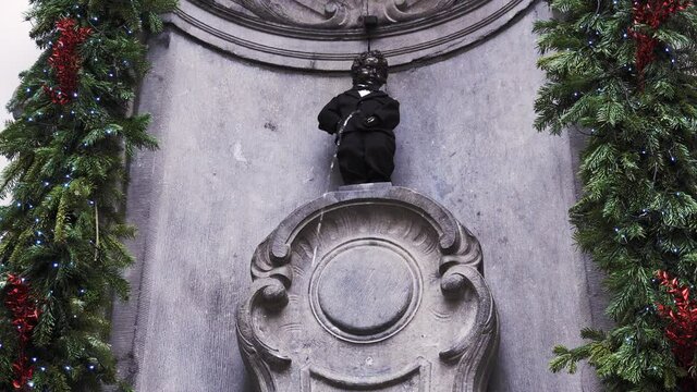 the 400 years birthday of famous statue of the manneken pis brussels belgium peeing boy in suite and birthday cake with number 400
