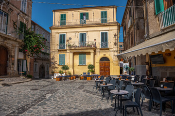typowy widok w małych miasteczkach na południu Włoch - rynek w otoczeniu kamienic z małymi...
