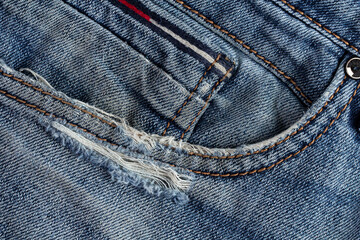 Faded side pocket in old jeans, copy space.