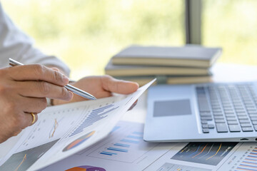 Businessman analyzing the graph at desk sales data and economic growth graph chart. Business strategy. Preparing report