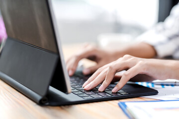 Naklejka na ściany i meble Image of woman hand working using tablet keyboard at office..