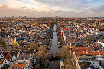 Obraz premium Sunset Over Amsterdam City with its Canals and Waterways Aerial View