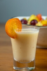 natural yogurt served in a transparent container decorated with mini orange, with fruit salad