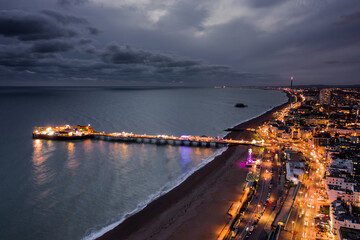 Fototapeta na wymiar Brighton Palace Pier Illuminated at Night Along the Seafront Aerial View