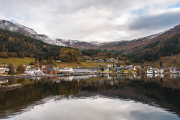 Fototapeta na wymiar Small Town on the Shores of a Fjord in Norway Reflected in the Waters