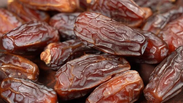 Close-up view 4K stock video footage of tasty brown dried dates fruit isolated on brown background
