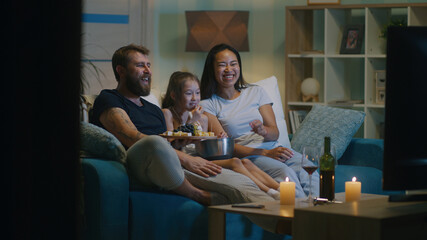 Multiethnic family watching funny film together