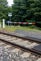 Fototapeta premium Forest footpath closed by a barrier before entering the tracks.
